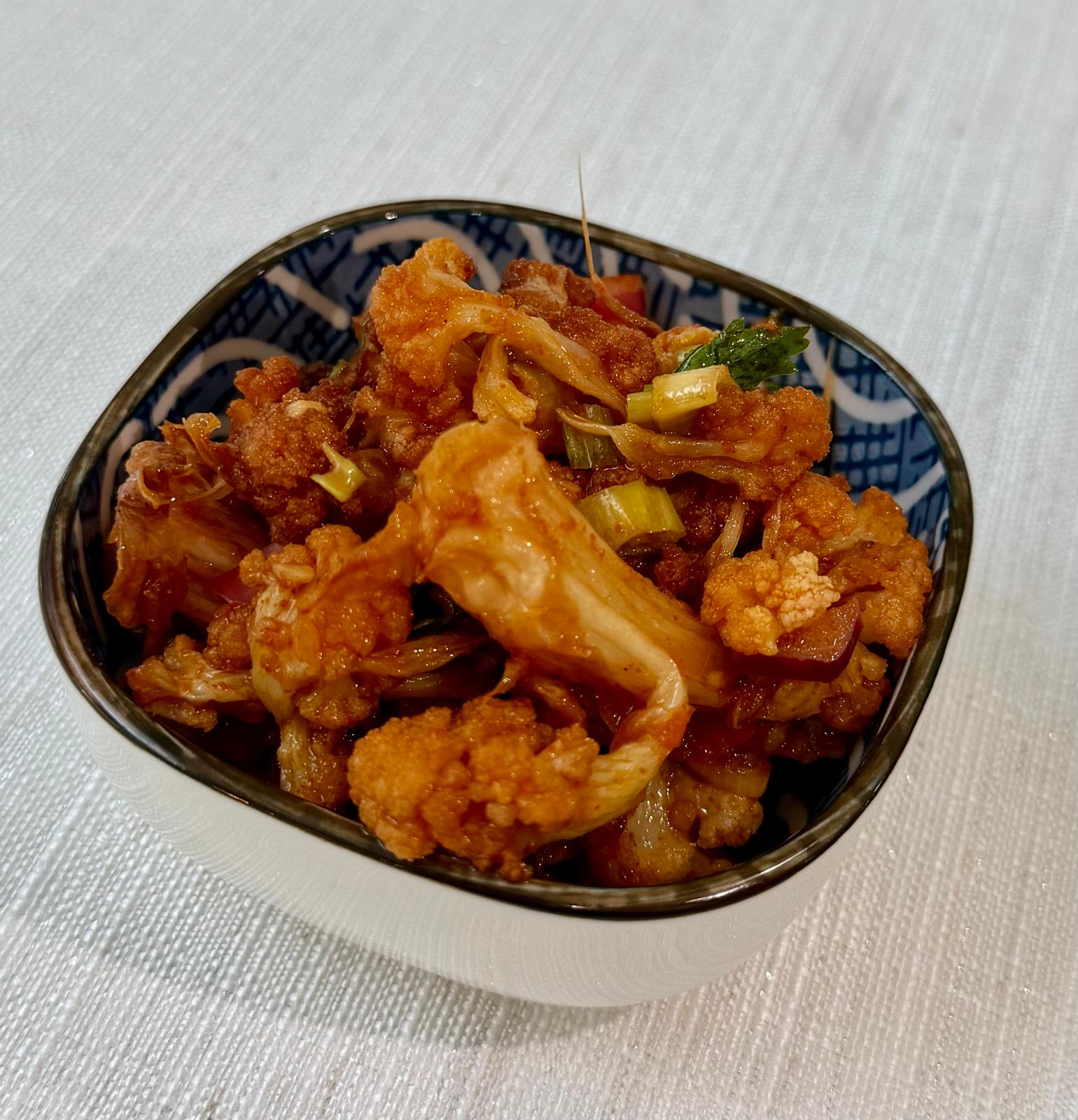 Fried cauliflower in spiced tomato sauce with scallions